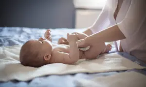 Mama zmienia pieluszkę niemowlaka, który ma biegunkę.