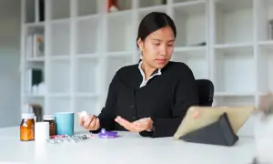 Kobieta z tabletką w dłoni, obok leki, w tym naproxen Hasco.