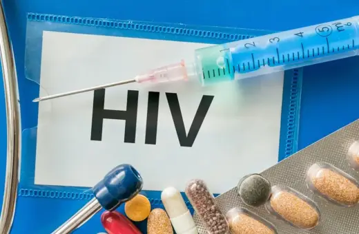 Strzykawka, tabletki i stetoskop na tle napisu "HIV". Wiedza o tym, hiv co to, jest kluczowa.